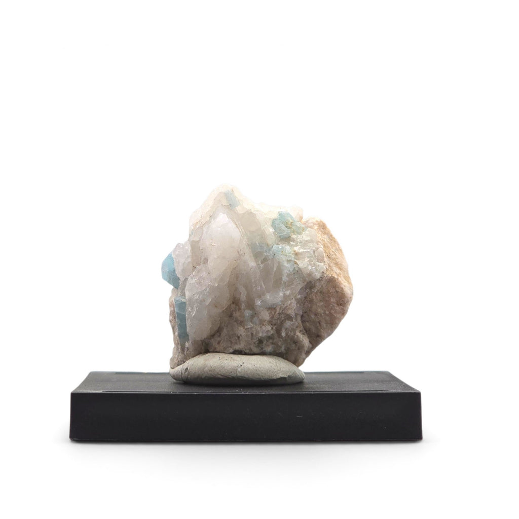 Angled view of translucent white matrix with several pale blue aquamarine crystals