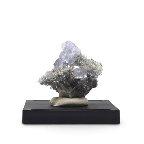 Front view of pale blue fluorite with sparkling slender quartz crystals on dark matrix