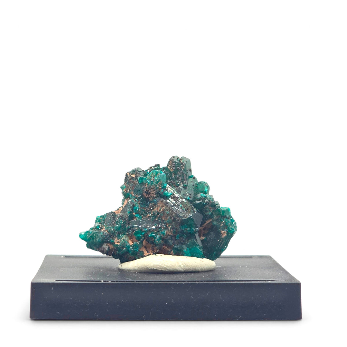 Dioptase and chrysocolla specimen mounted on a black base beneath a clear display cover