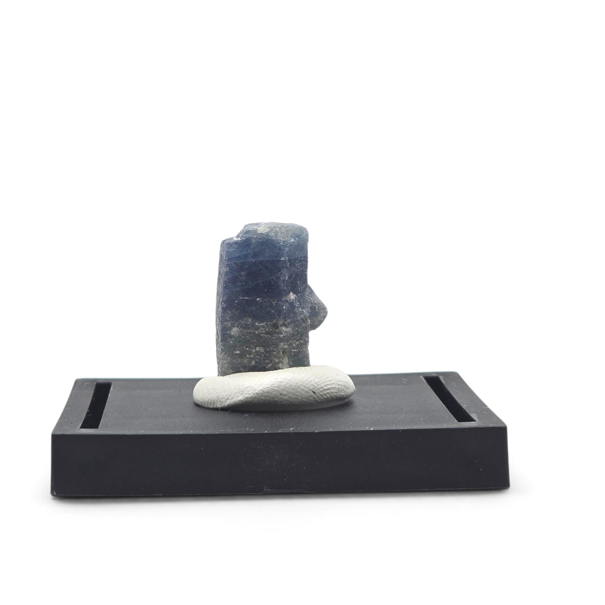 Front view of a dark blue sapphire crystal mounted upright on a black display base