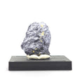 Front view of a dark lead-gray metallic molybdenite specimen mounted upright on a black base