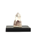 Front view of a clear quartz cluster with a reddish-brown internal phantom on a black display base